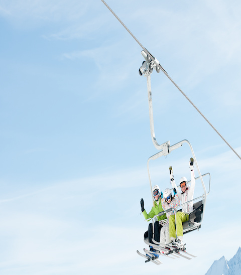 Winter vacation, family on ski lift - space for text